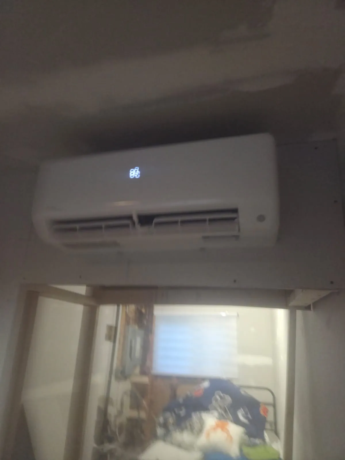 Ductless wall unit above a doorway in a finished basement