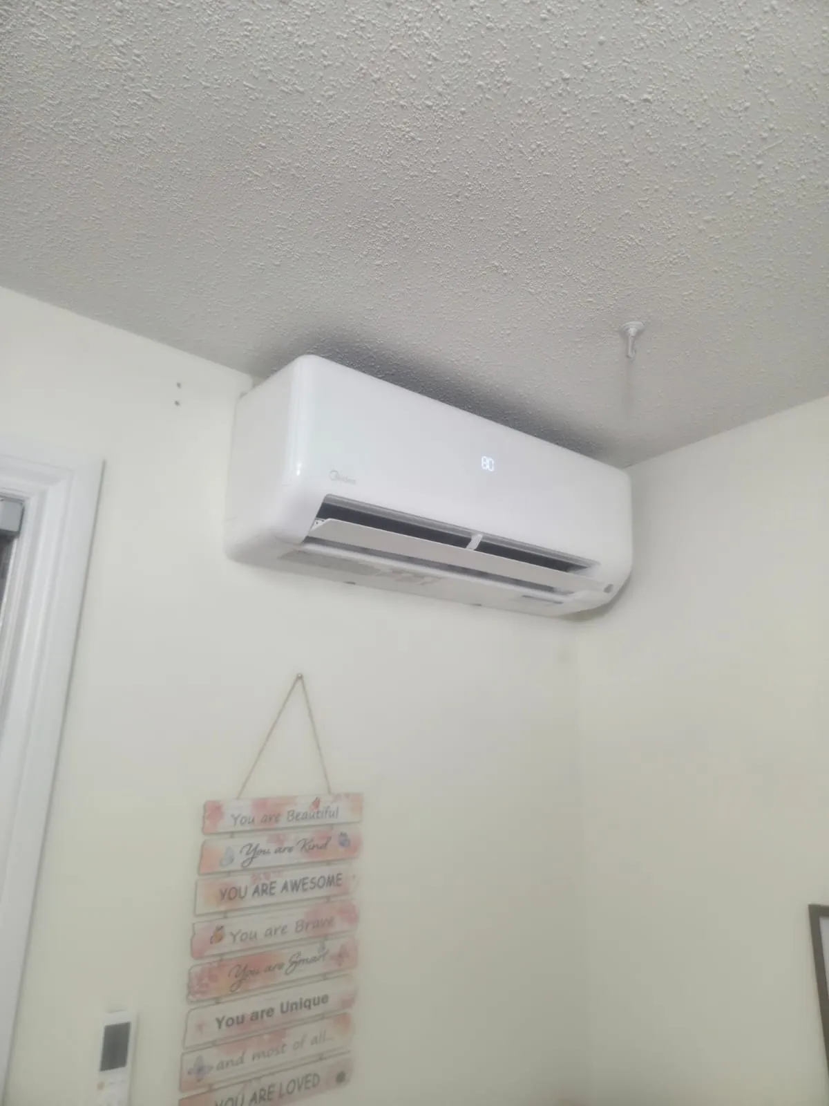 Ductless wall unit installed high in a bedroom corner