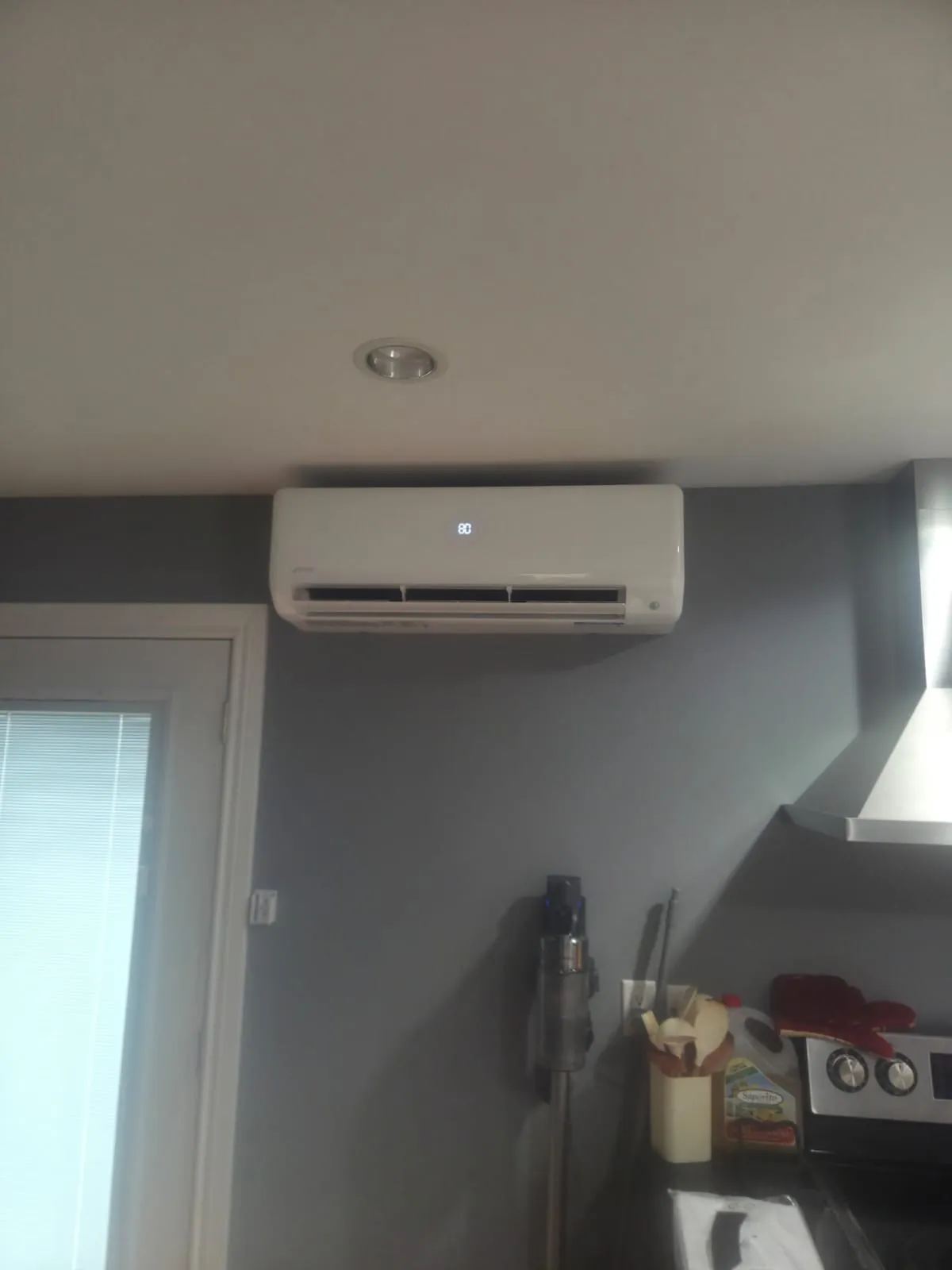 Ductless wall unit above a patio door in an open kitchen