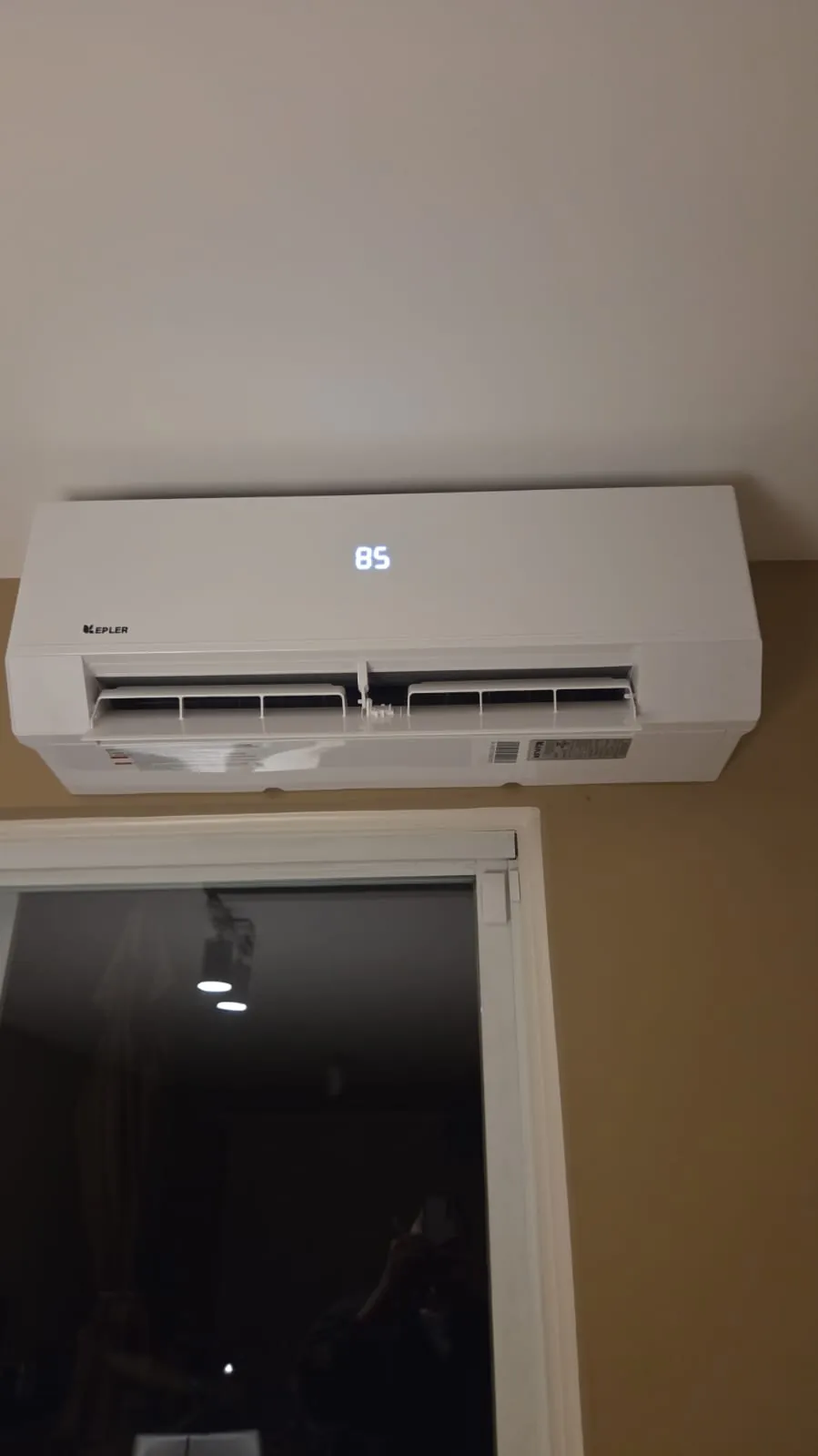 Ductless wall unit above a doorway with the display lit