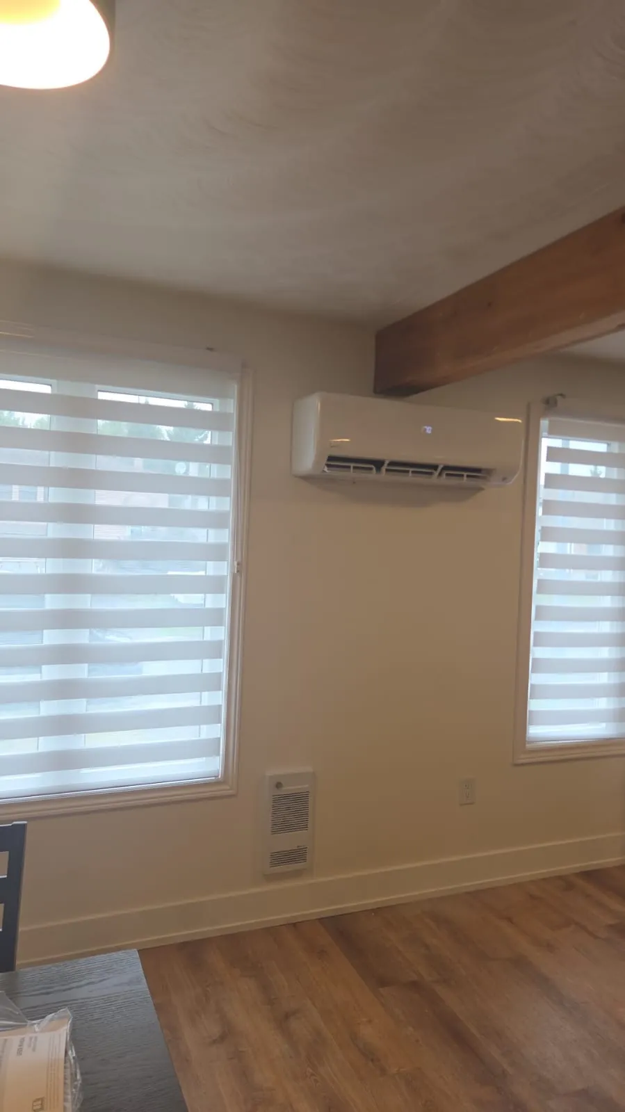 Ductless wall unit between two windows under a wood beam