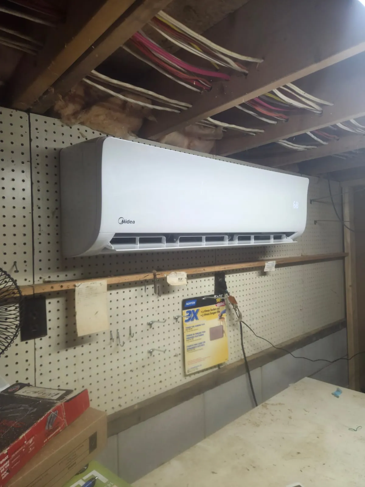 Midea ductless unit on a pegboard wall in a basement workshop