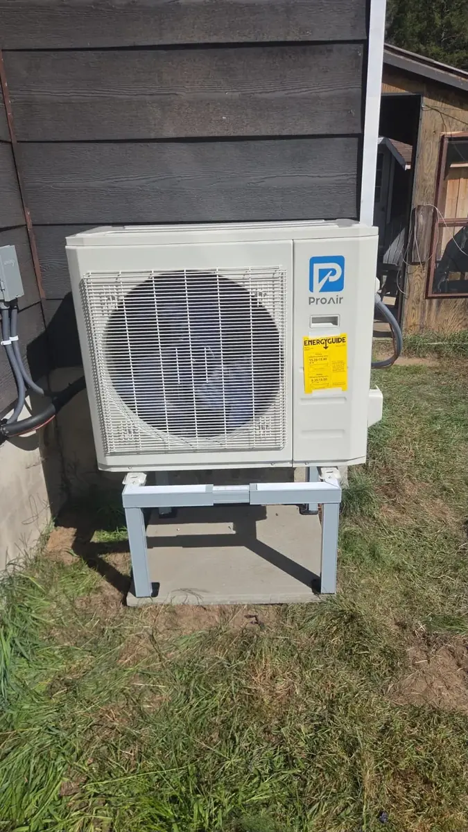 Outdoor heat pump on a raised stand above the lawn