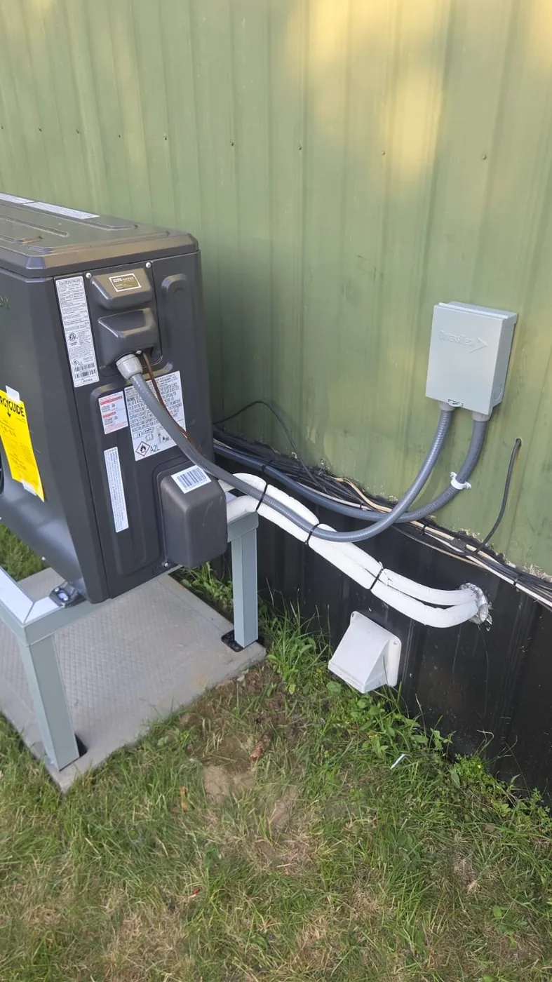 Side view of a Midea cold-climate heat pump with line set, disconnect and condensate line