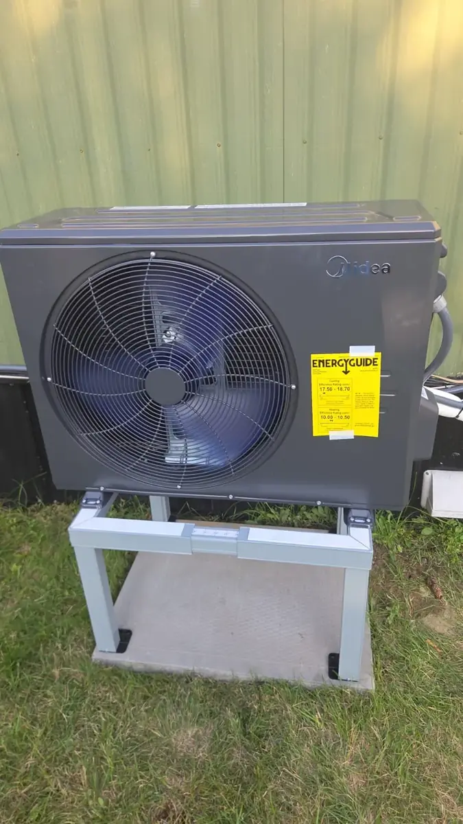 Midea cold-climate heat pump on a stand and pad
