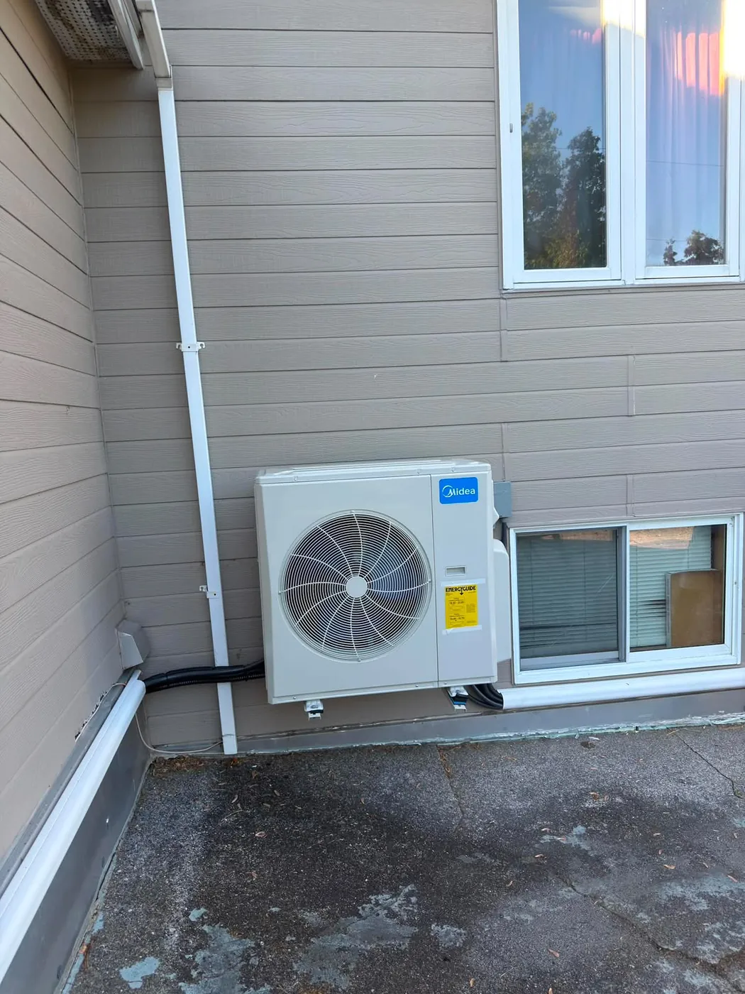 Midea ductless outdoor unit on a patio with a white line set cover