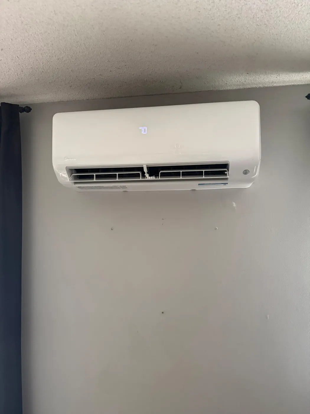 Midea ductless head mounted high on a grey wall