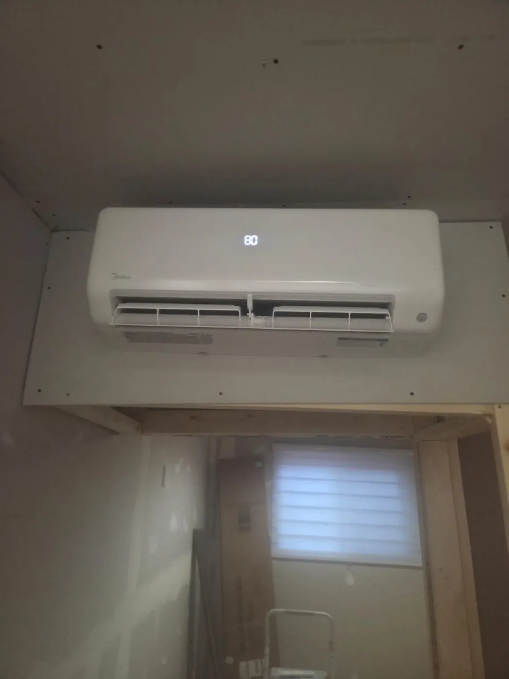 Midea ductless head above a window in a finished room